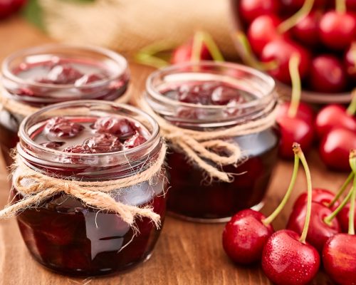 Cherry jam on wooden ground with fresh cherries